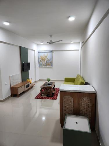 un soggiorno con divano e tavolo di Anandi Service Apartment a Pune