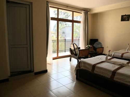 a bedroom with a bed and a view of a balcony at Honey Guest House in Lalībela