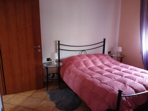 a bed with a pink comforter in a bedroom at Home Sweet Home in Bologna
