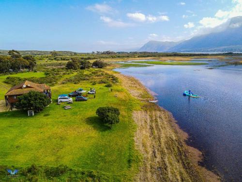 an aerial view of a lake with cars and a house at Rivers End Farm Stanford with solar energy in Stanford