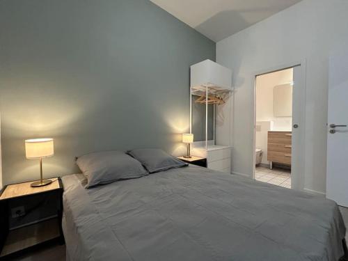 une chambre avec un grand lit et deux lampes dans l'établissement Pasteur, appartement fonctionnel en centre-ville, à Lorient