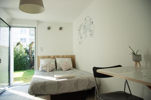 サン・セバスティアン・シュル・ロワールにあるAu clos du bonheurのベッドルーム1室(ベッド1台、テーブル、デスク付)