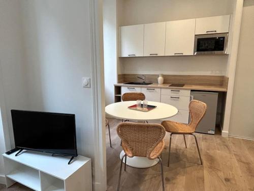sala de estar con mesa y sillas y cocina en Pasteur, appartement fonctionnel en centre-ville, en Lorient