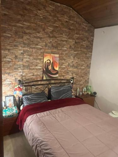 a bedroom with a brick wall and a bed at Μεζονέτα στους Αγίους Δέκα Κέρκυρας in Áyioi Dhéka