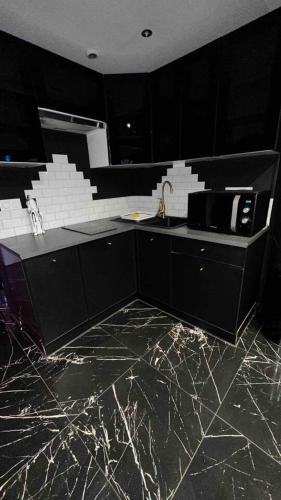 a kitchen with black cabinets and a marble floor at Appartement d'une chambre avec sauna et wifi a Villeurbanne in Villeurbanne