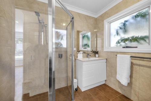 a bathroom with a shower and a sink at A Short time in Merimbula