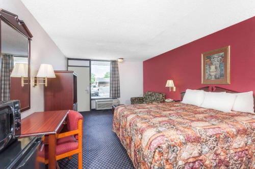 a hotel room with a bed and a desk at Days Inn by Wyndham Martin in Martin