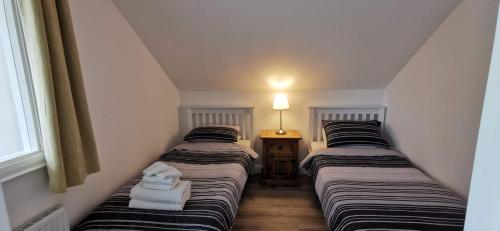 2 łóżka pojedyncze w pokoju z oknem w obiekcie Ocean Valley View Apartment w mieście Killybegs