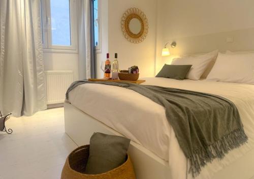 Schlafzimmer mit einem großen weißen Bett und einem Spiegel in der Unterkunft Acropolis Plaka Ambience Retreat in Athen