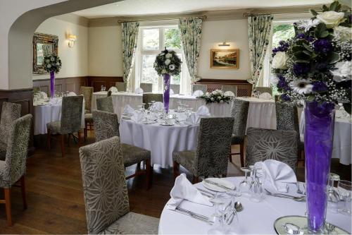 アイアンブリッジにあるベスト ウェスタン バレー ホテルの白いテーブルと紫の花瓶が飾られたダイニングルーム