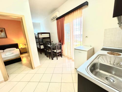 a kitchen with a sink and a room with a table at Ksamil Harmony Studios in Ksamil