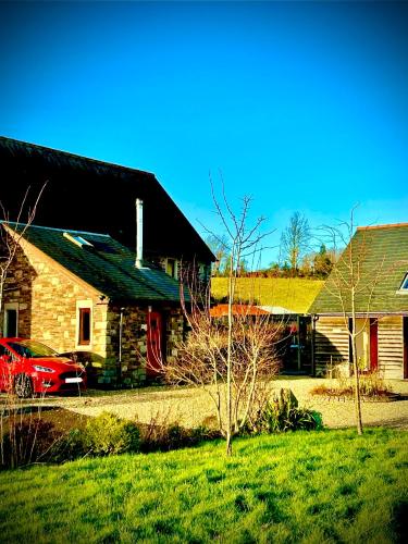 a red car parked in front of a stone house at Ty Odyn. Best of Both Worlds. Rural yet Connected. in Newport