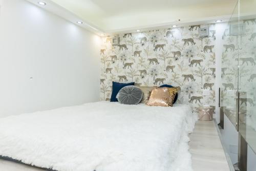 ein Schlafzimmer mit einem weißen Bett und einer Wand mit Hirschtapete in der Unterkunft Zichy Luxury Apartment in Budapest