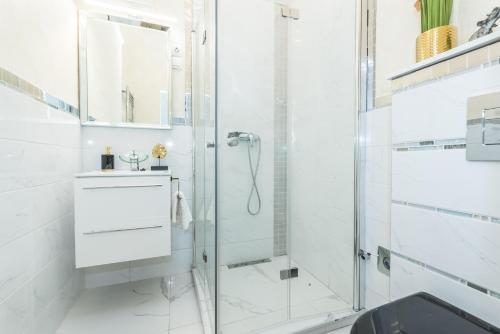 ein weißes Bad mit einer Dusche und einem Waschbecken in der Unterkunft Zichy Luxury Apartment in Budapest