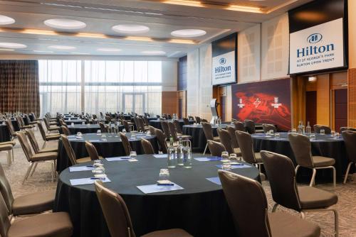 a conference room with tables and chairs and a stage at Hilton at St George's Park in Burton upon Trent
