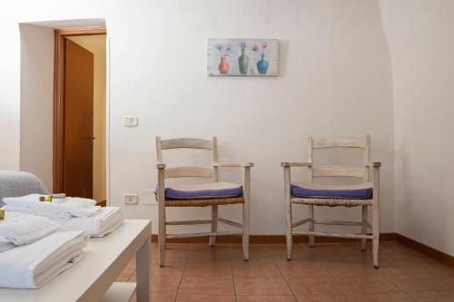 two chairs sitting in a room with a table at Casa Vèra Camelia Apartment in Orvieto