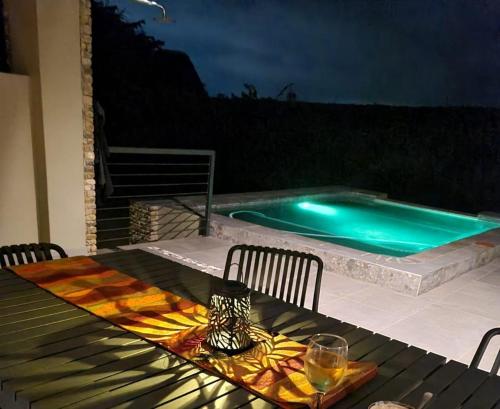 uma mesa com um copo de vinho em cima de uma mesa com piscina em Rosendal Kruger View Villa em Marloth Park