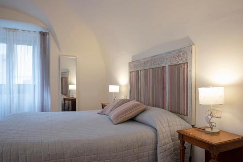 ein Schlafzimmer mit einem Bett, zwei Lampen und einem Spiegel in der Unterkunft Casa Vèra Camelia Apartment in Orvieto
