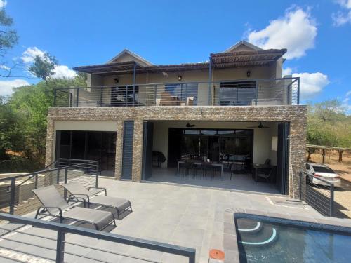 uma casa com um pátio e uma piscina em Rosendal Kruger View Villa em Marloth Park
