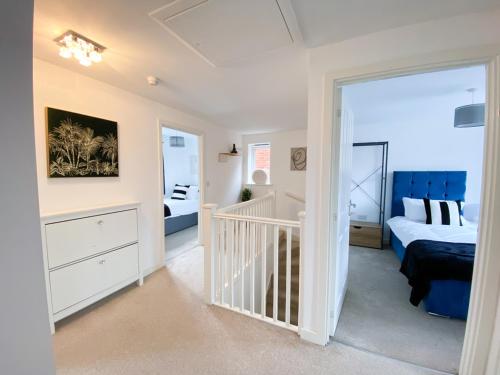 a bedroom with a bed and a crib at Spacious 4 Bed Peterborough House With Parking in Peterborough