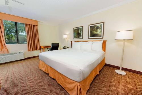 a hotel room with a large bed and a window at La Quinta by Wyndham Ft Lauderdale Cypress Creek in Fort Lauderdale