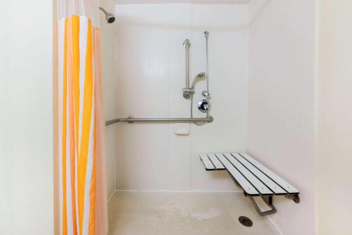 a bathroom with a shower with a bench in it at La Quinta by Wyndham Ft Lauderdale Cypress Creek in Fort Lauderdale