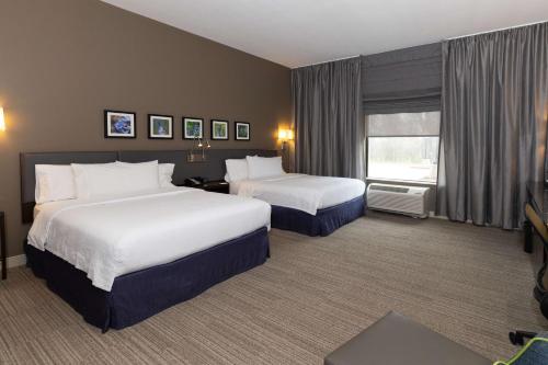 Hilton Garden Inn Austin Airport في أوستن: غرفة فندقية بسريرين ونافذة