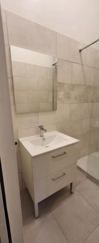 une salle de bain blanche avec un lavabo et une douche dans l'établissement Joli studio meublé très calme 15mn des plages et wifi gratuit, à Marseille