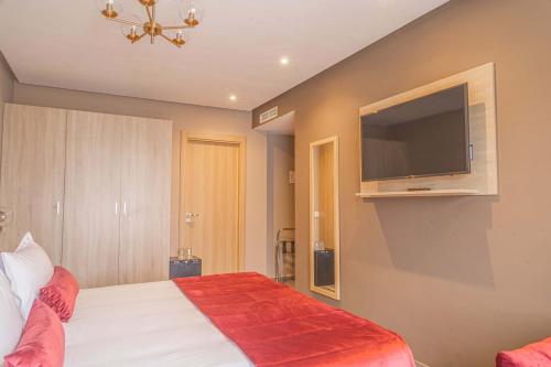 a bedroom with a bed and a flat screen tv at Rent-inn Boutique Hotel in Rabat