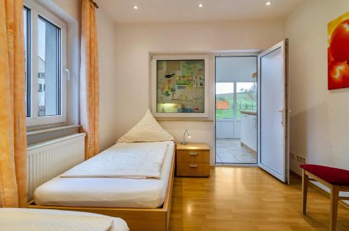 HödingenにあるHaus Nussbaumのベッド2台、窓、テーブルが備わる客室です。