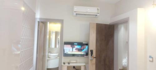 a bathroom with a tv on the wall in a room at Buddha Stays in Varanasi