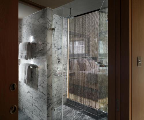 a bathroom with a shower with a glass door at The Hari London in London