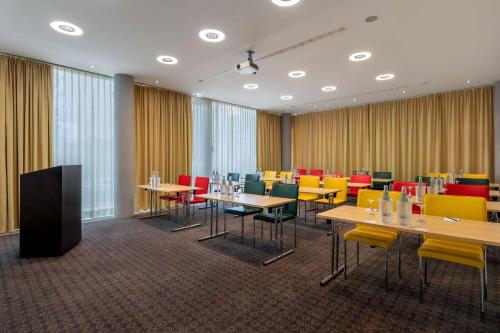 a conference room with tables and colorful chairs at DoubleTree by Hilton Frankfurt Niederrad in Frankfurt/Main