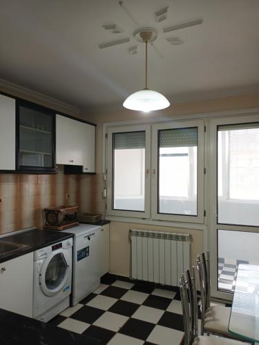 a kitchen with a washing machine and a checkered floor at Апартамент Първанова in Montana