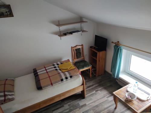 a small bedroom with a bed and a table at Gospodarstwo Agroturystyczne Agroletnica in Świdnica