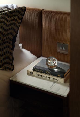 two books on a table with a clock on top at The Hari London in London