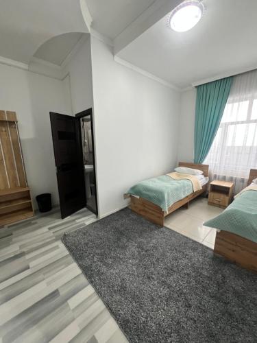 卡拉科爾的住宿－Sayak hostel，一间带两张床的卧室和地毯