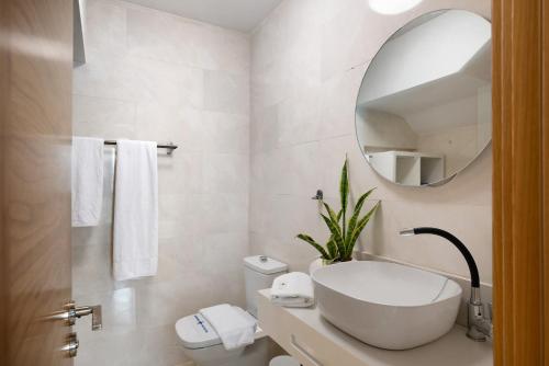 a white bathroom with a sink and a mirror at Casa Africa in Tahiche