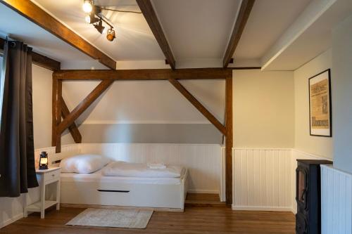 a bed in a room with wooden beams at Rustic Charm - Cottage by Comfort Housing in Kolonie Neudöberitz