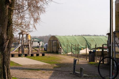 a playground with a green tent and a slide at Rustic Charm - Cottage by Comfort Housing in Kolonie Neudöberitz