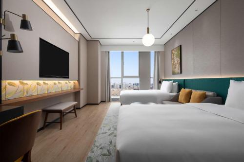 Postel nebo postele na pokoji v ubytování Hilton Garden Inn Beijing Daxing Jinyuan Road