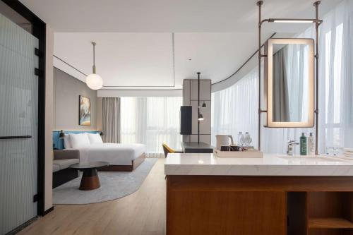 a bathroom with a sink and a bedroom with a bed at Hilton Garden Inn Beijing Daxing Jinyuan Road in Beijing
