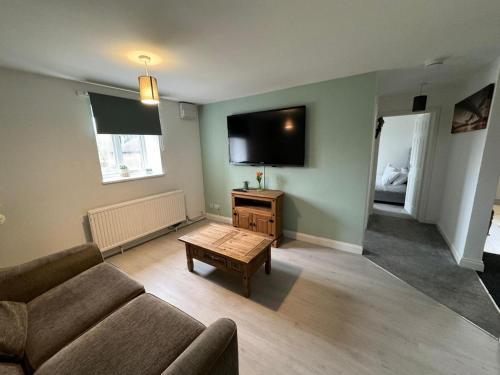 sala de estar con sofá y TV de pantalla plana en Town centre cosy 2 bedroom apartment, en Market Deeping