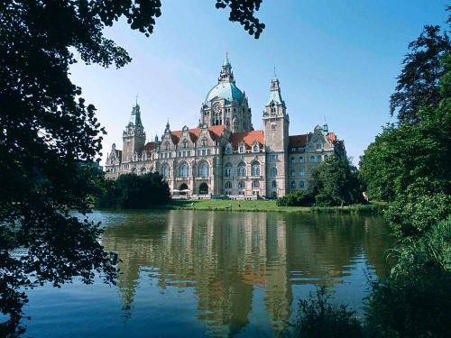 ein großes Gebäude mit einer Reflexion im Wasser in der Unterkunft Fora Hotel Hannover by Mercure in Hannover