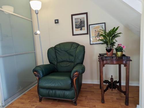 a green chair in a room with a table at Sherlock's House - Two bedroom terrace 3 beds 2 sofa beds Garden Private free parking & WIFI Accessibility Contractors Family & Kids & Pet are welcome in Church Gresley