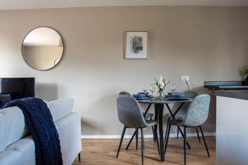 a dining room with a table with chairs and a mirror at Perth House in Clydebank