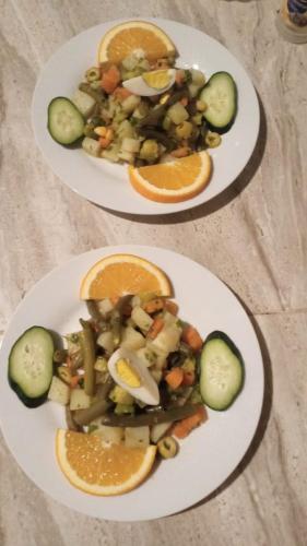 two plates of food with vegetables and orange slices at Gite d'étape nomade in Tajda