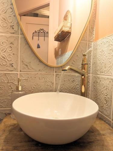 une salle de bain avec un lavabo blanc et un miroir dans l'établissement Maison Pimoli : Chambre Garance, à Soustons