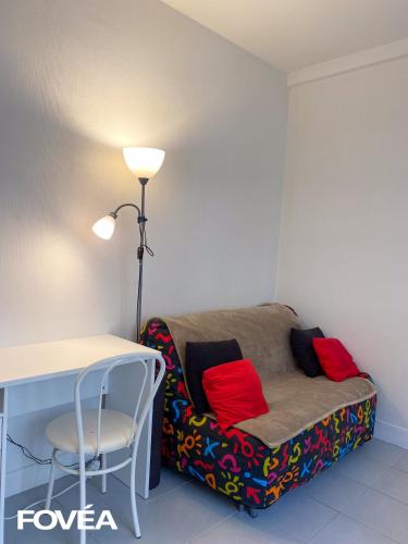 Habitación con sofá, mesa y lámpara. en Basse en Caen