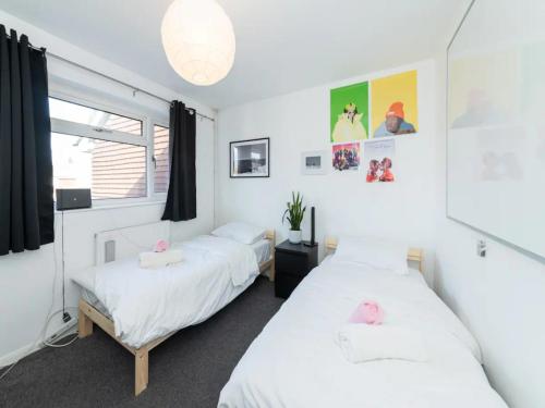 a bedroom with two beds and a window at Pass the Keys Heart of Emmer Green with Stylish Interiors in Reading